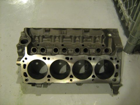1988 Mercury Grand Marquis - A metal engine block with visible cylinder bores is shown from a side angle.