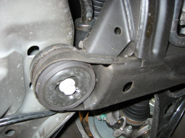 Underside view of black rubber bushing with center bolt and mounting bracket