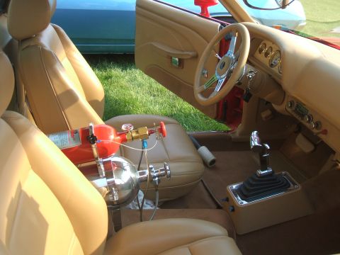 1974 Ford Ranchero - The interior of a car shows a nitrous oxide system installed, with tan upholstery and a chrome shifter.