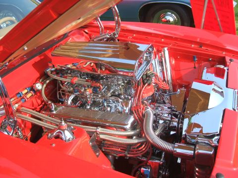 1974 Ford Ranchero - A highly customized engine bay features extensive chrome detailing and vibrant red spark plug wires, with a Supermotors.net logo in the cor…