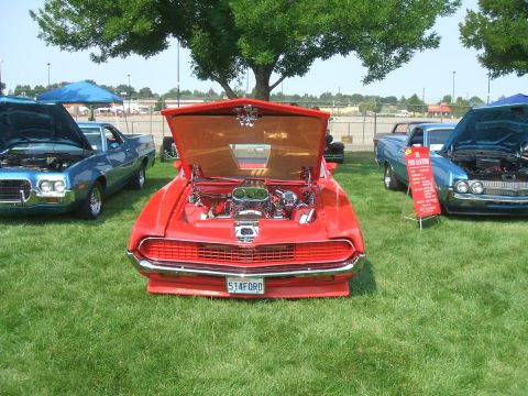 1974 Ford Ranchero - Custom red car with engine exposed at a car show, alongside other vehicles.