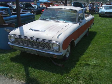 1974 Ford Ranchero - A weathered 1964 Ford Falcon Ranchero sits on display at a car show, its distinctive two-tone paint visible.