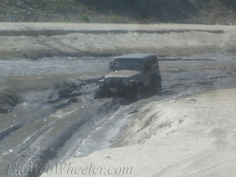 1987 Suzuki Samurai - A Jeep Wrangler struggles through a muddy off-road course.