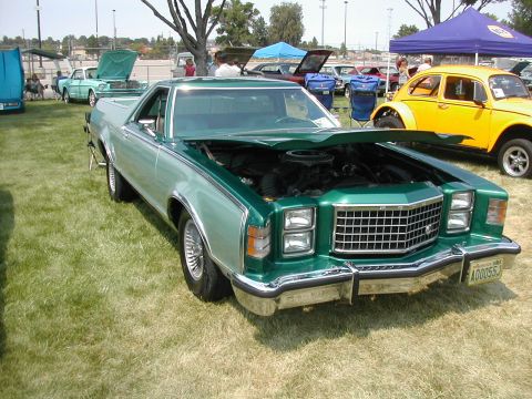 1972 Ford Ranchero - Green 1977 Ford Ranchero with hood open, displaying its engine. The vehicle is parked on grass at an outdoor event.