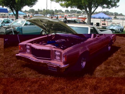 1972 Ford Ranchero - A pink 1972 Ford Ranchero is displayed with its hood open at an outdoor car show.