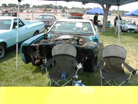 1972 Ford Ranchero - A blue car with its hood open, revealing the engine, sits on display at an outdoor car show.