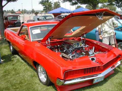 1972 Ford Ranchero - A red 1970 Ford Ranchero is displayed with its hood open, revealing a polished engine and custom wheels.