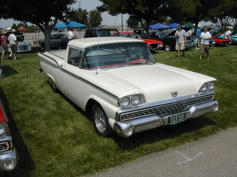 1972 Ford Ranchero - A white 1959 Ford Ranchero is displayed at an outdoor car show with other vehicles in the background.