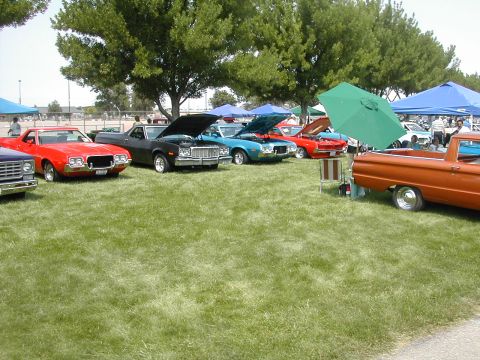 1972 Ford Ranchero - Several Ford Rancheros and other vehicles are displayed on a grassy field under tents and trees.