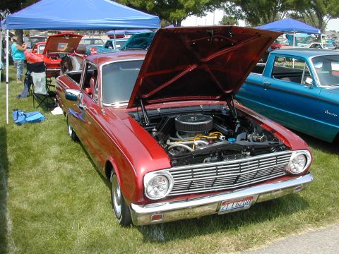 1972 Ford Ranchero - A red 1965 Ford Ranchero is displayed with its hood up, parked on grass next to a blue pickup truck.