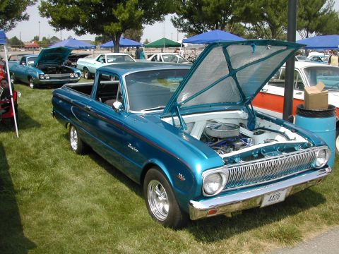 1972 Ford Ranchero - A blue pickup truck, likely from the early 1960s, is displayed with its hood open at an outdoor event.
