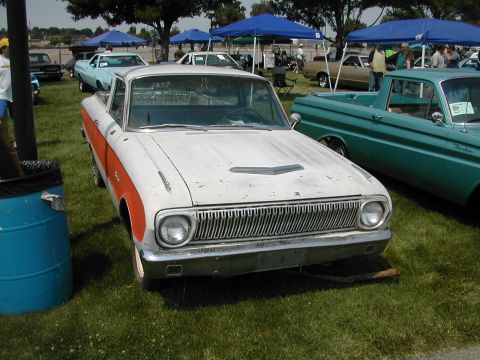 1972 Ford Ranchero - White and orange 1966 Ford Falcon Ranchero at a car show, with other vehicles and tents in the background.