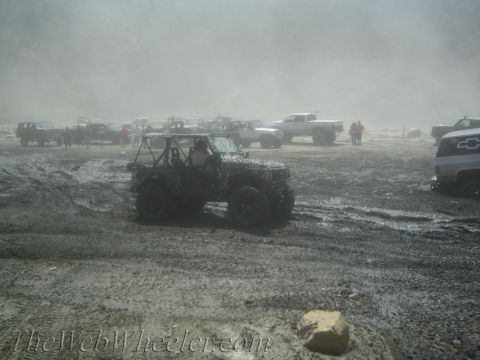 1987 Suzuki Samurai - Several off-road vehicles are gathered in a dusty, muddy environment, with one prominently in the foreground.