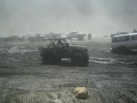1987 Suzuki Samurai - Multiple off-road vehicles navigate a muddy and dusty terrain, suggesting an off-road event or challenge.