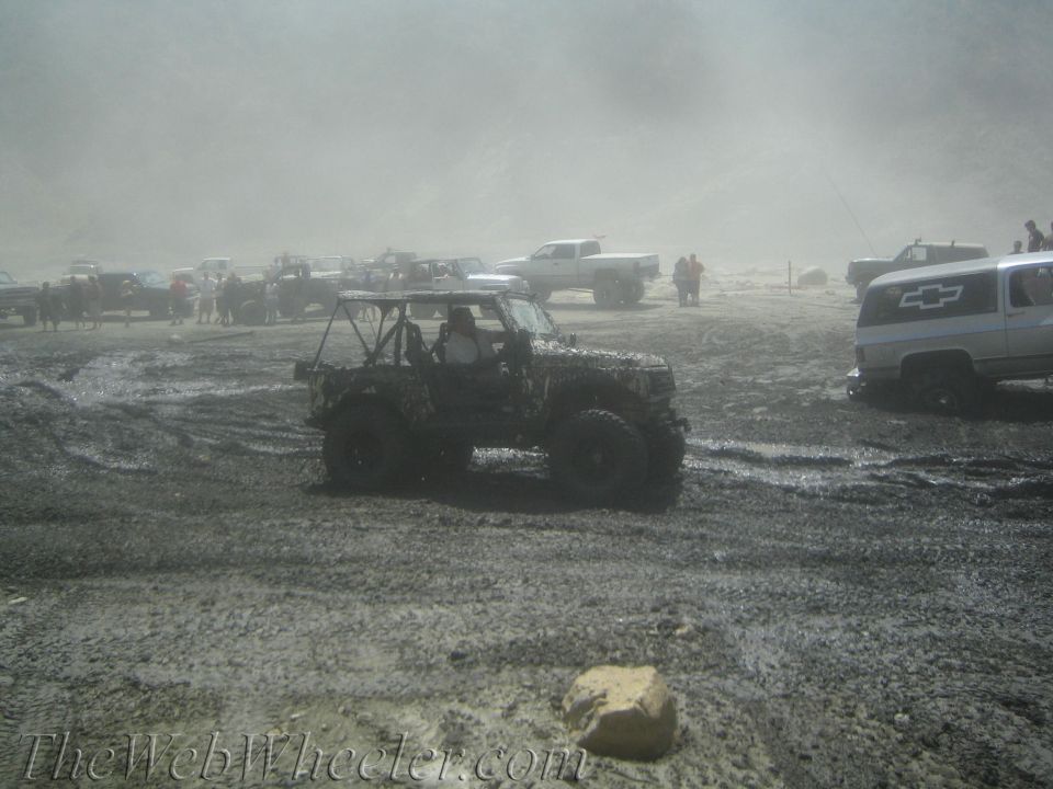 Muddy off-road vehicles in a dusty, muddy scene