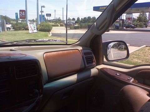 2000 Ford Excursion - Interior view of a 2000 Ford Excursion, with a gas station visible in the side mirror.
