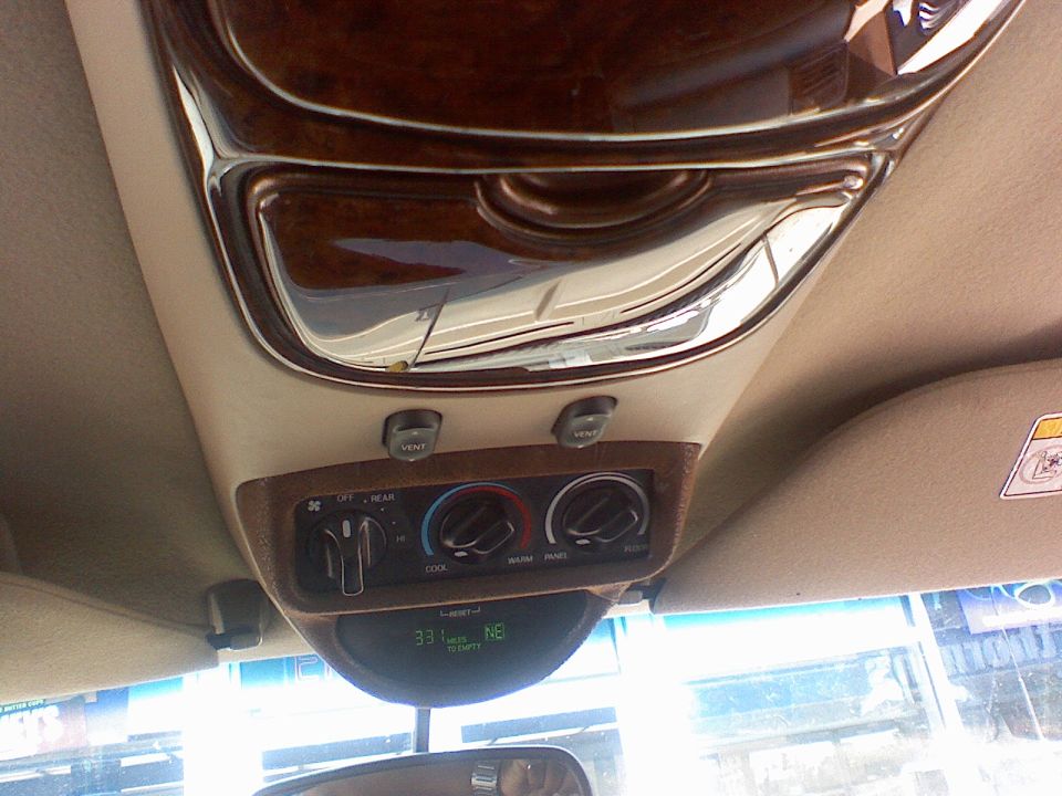 Vehicle overhead console with rear climate controls and compass temperature display reading 33 degrees NE