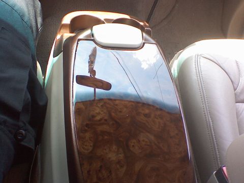 2000 Ford Excursion - The glossy finish of the center console reflects the sky and a rearview mirror.