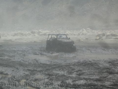 1987 Suzuki Samurai - This 1987 Suzuki Samurai is deep in the mud, struggling to move forward.