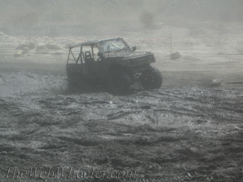 1987 Suzuki Samurai - This 1987 Suzuki Samurai navigates a muddy terrain, kicking up spray as it goes.