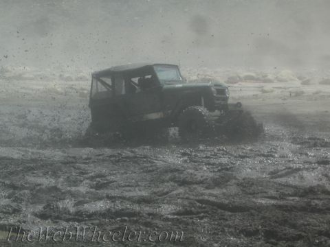 1987 Suzuki Samurai - Suzuki Samurai navigating a muddy terrain, with significant mud spray.