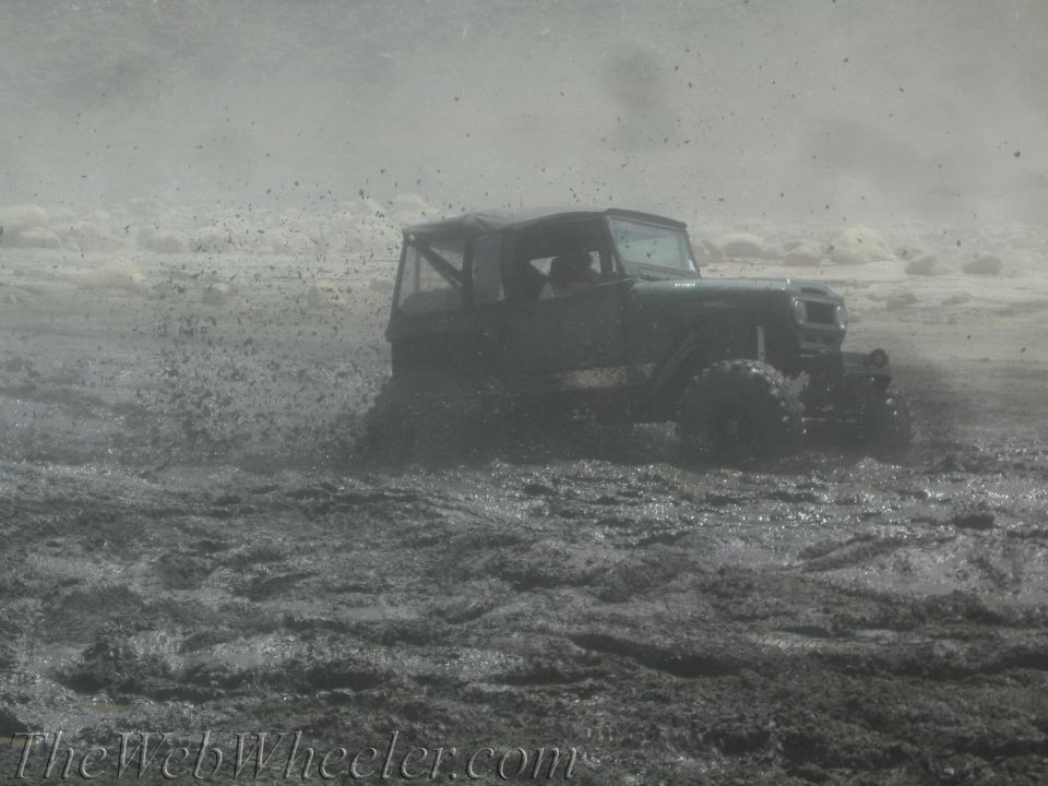 Jeep-like vehicle splashing through thick mud
