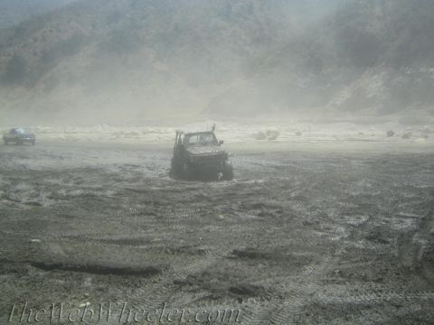 1987 Suzuki Samurai - Two vehicles are visible in a muddy, off-road environment; one is stuck.