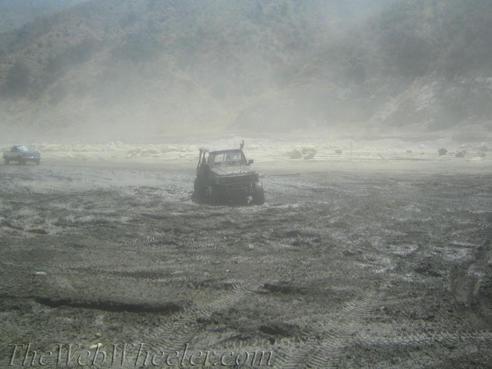 Off-road vehicle stuck in mud with another vehicle in the distance