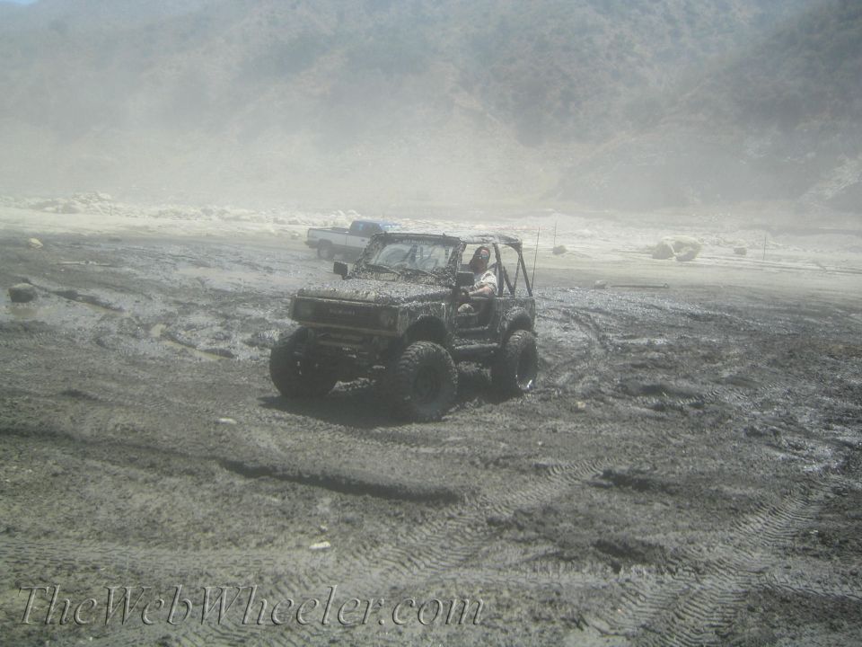 1987 Suzuki Samurai driving through mud, 3q-front view