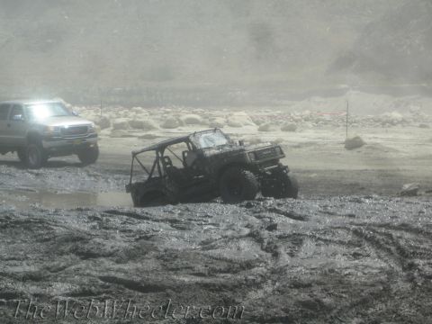 1987 Suzuki Samurai - A 1987 Suzuki Samurai navigates a muddy off-road course, with another truck visible in the background.