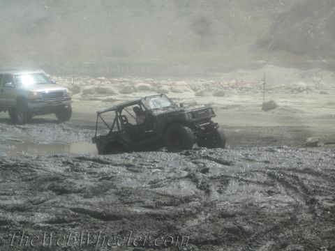 1987 Suzuki Samurai - Off-road vehicles struggle to navigate through a muddy terrain.