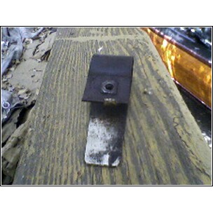 1972 Ford Ranchero - A black metal bracket with a nut is shown resting on a weathered wooden surface. The SuperMotors logo is visible at the bottom.