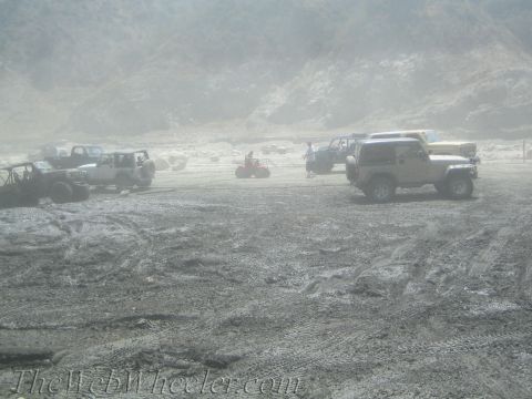1987 Suzuki Samurai - Several off-road vehicles are gathered in a dusty and muddy terrain, suggesting an outdoor recreational event.