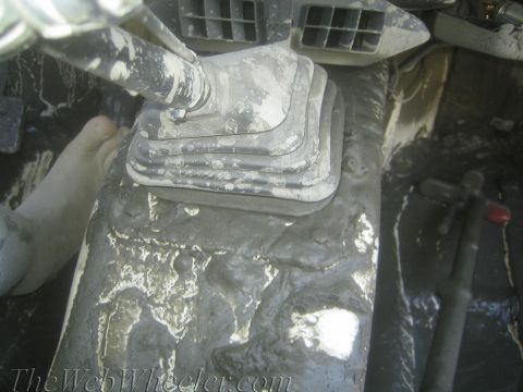 1987 Suzuki Samurai - The interior of a vehicle is heavily covered in mud, obscuring most details.