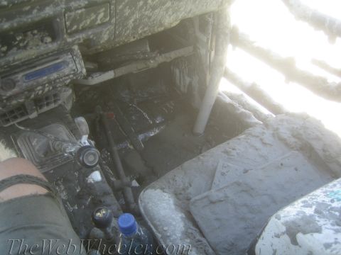 1987 Suzuki Samurai - The interior of a vehicle is heavily covered in mud, obscuring most details.