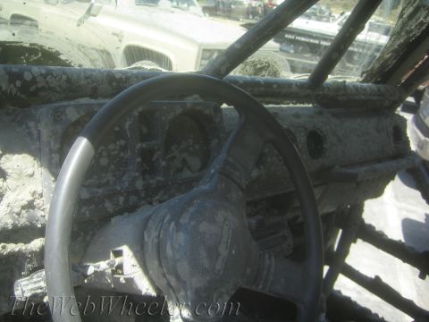 1987 Suzuki Samurai - The interior of an off-road vehicle is heavily covered in mud, obscuring most details.