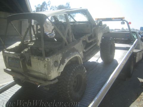 1987 Suzuki Samurai - This heavily mud-caked 1987 Suzuki Samurai is being transported on a tow truck.