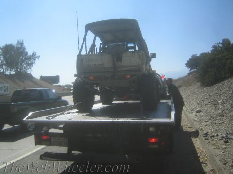 1987 Suzuki Samurai - A white 1987 Suzuki Samurai is loaded onto a flatbed truck, viewed from the rear.