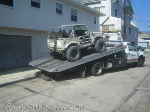 1987 Suzuki Samurai - A heavily modified 1987 Suzuki Samurai is loaded onto a flatbed tow truck.