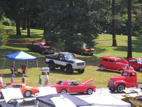1994 Ford Bronco - Outdoor car show multiple vehicles from different eras on display.