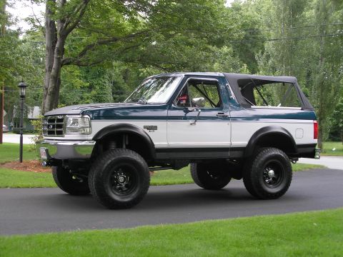 1994 Ford Bronco - This lifted 1994 Ford Bronco features a two-tone green and white paint scheme with a removable soft top.