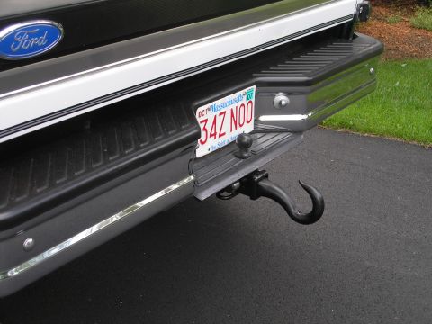 1994 Ford Bronco - The rear of a Ford truck shows a license plate and a trailer hitch with a hook attachment.