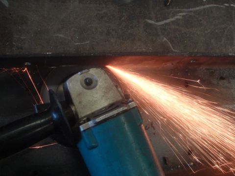 1996 Ford Bronco - An angle grinder in action, showering sparks as it cuts through metal.
