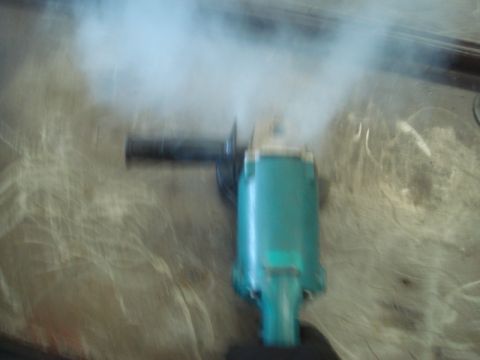 1996 Ford Bronco - Angle grinder in operation, producing smoke.