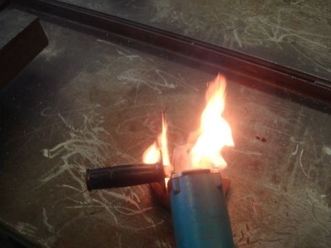 1996 Ford Bronco - An angle grinder is on fire, with flames erupting from its cutting disc area.