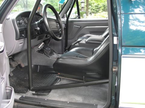 1994 Ford Bronco - The interior of a 1994 Ford Bronco features racing seats and a roll cage.