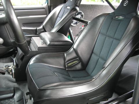 1994 Ford Bronco - The interior of the vehicle features racing seats and a roll cage, suggesting performance modifications.
