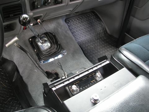 1994 Ford Bronco - The interior of a 1994 Ford Bronco features a manual floor shifter and an aftermarket stereo system.