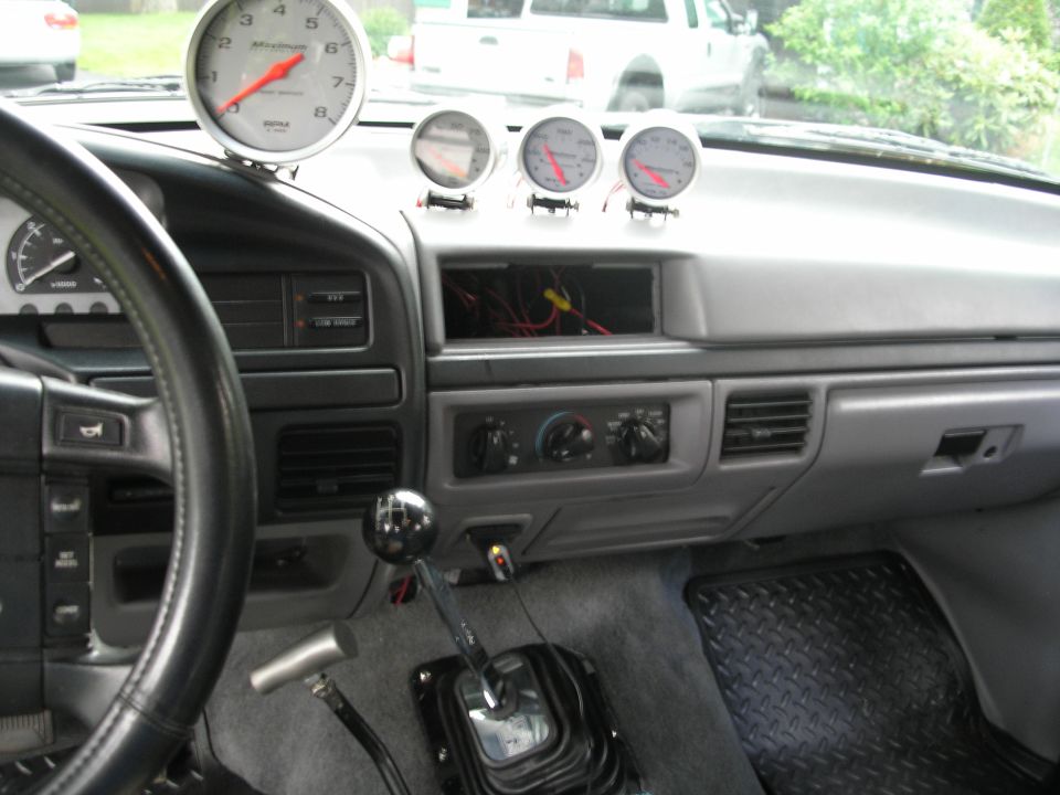 1994 Ford Bronco interior with tachometer and three gauges above the dash