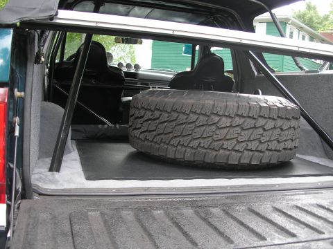 1994 Ford Bronco - Spare tire and roll cage installed in the cargo area of a 1994 Ford Bronco.